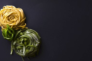 Siyah zemin üzerinde İtalyan spagettisi ve zeytinyağı şişesi ve merdane iğnesi..