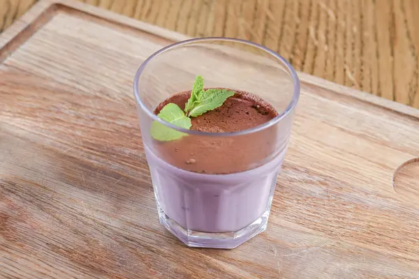 Sobremesa de panna cotta italiana com lavanda e mirtilo servida em um copo em uma tábua de madeira sobre mesa de madeira rústica . — Fotografia de Stock