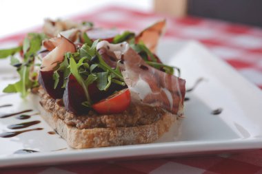 Kızarmış domatesli İtalyan aperatif bruschetta, mozzarella peyniri, sarımsak, otlar, prosciutto crudo ve sos..