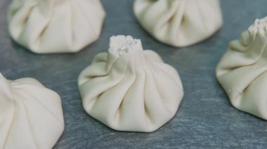 İçinde et olan Khinkali hamuru. Ulusal Gürcü yemekleri pişirmek. Köy tahtasında çiğ khinkali.