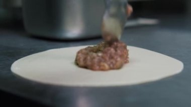 Yemek video konsepti. Aşçı khinkali yapıyor. Ulusal Gürcü mutfağı. Hamura et koyup khinkali yapıyorum..
