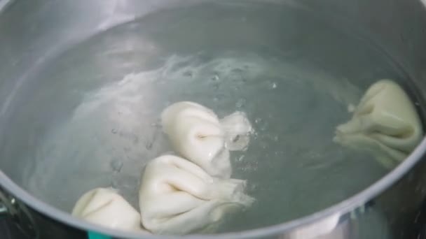 Georgian cuisine. Khinkali or dumplings are boiling in boiled water on the stove in a saucepan. Cooking process. — Stok video