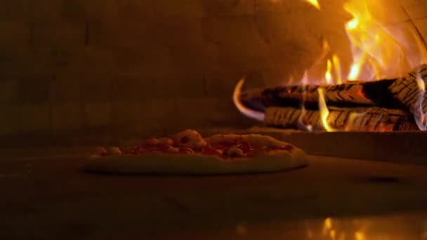 이탈리아 피자 페퍼로니는 오븐에서, 전통적 인 레스토랑에서 불에 구워 지는 나무 오븐에서 요리하는 식당 피자. — 비디오