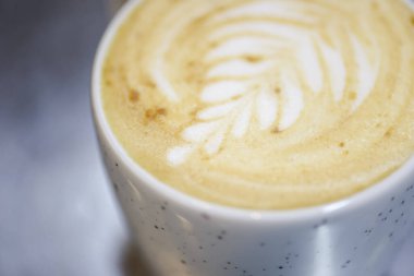 Sütlü bir fincan kahve. Geç sanat eserleri. Arka plan bulanık. Sıcak mevsimlik içecek.