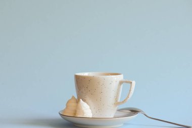 Açık renkli mavi arka planda izole edilmiş beyaz bir fincanda bir fincan kahve veya americano..