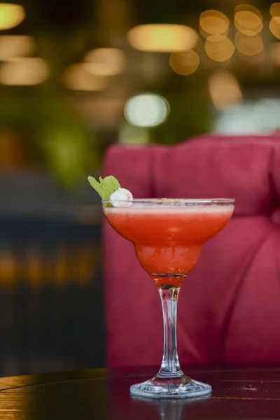 Koude zomer alcohol cocktail met ijs en fruit in een hoog glas op licht wazig restaurant of cafe achtergrond. — Stockfoto