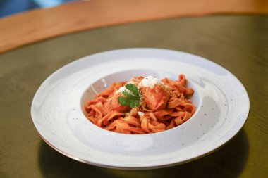 Bolonez soslu makarna ve siyah ahşap masada beyaz tabakta parmesan peyniri..