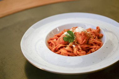 Bolonez soslu makarna ve siyah ahşap masada beyaz tabakta parmesan peyniri..