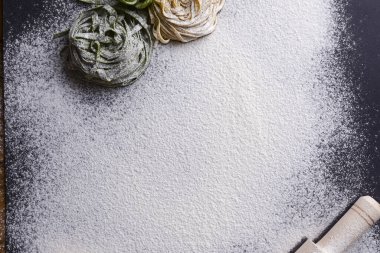 Siyah zemin üzerinde İtalyan spagettisi ve zeytinyağı şişesi ve merdane iğnesi..