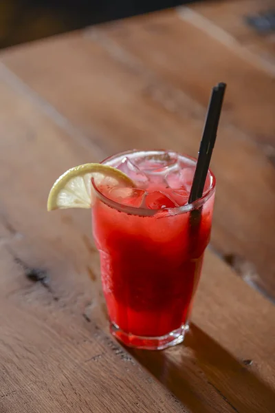 Classic alcoholic summer cocktail with lemon and mint garnish on a bar table.