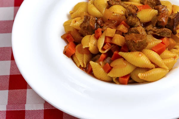 Makaronpasta med köttbitar i tomatsås och grönsaker i skål. Ovanifrån. — Stockfoto