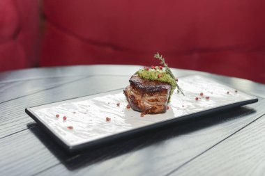 Koyu kırsal ahşap masada beyaz bir tabakta servis edilen sebzelerle iştah açıcı kazık..