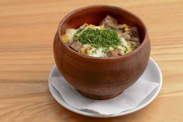 Beef meat stewed with potatoes, cheese and spices, goulash. Potato stew in ceramic bowl.