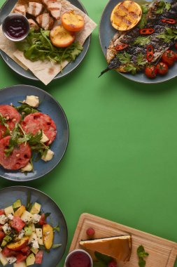 Yaz mutfağı düzlüğü: caprese, ızgara tavuk, geleneksel New York peynirli keki, parlak yeşil arka planda kavun..