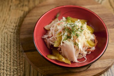 Kırmızı kasede salatalık turşusu ve dereotlu taze lahana salatası. Alman lahana turşusu.