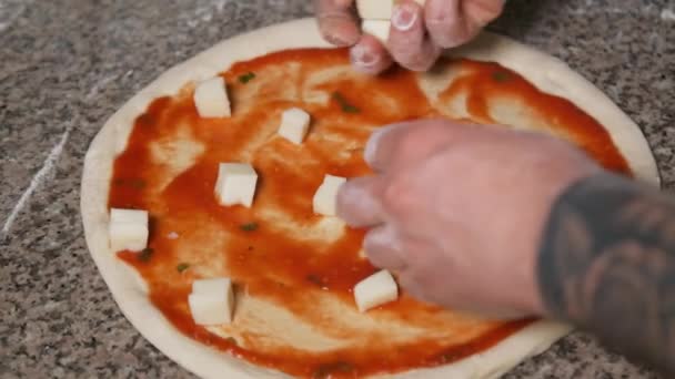 Üniformalı fırıncının elleri pizzaya pepperoni ekliyor. Pizza Sanatı. Pizza yapma süreci.. — Stok video
