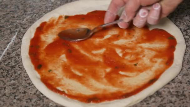 Mani di chef panettiere in uniforme aggiungendo salame piccante nella pizza. Pizza Art. Il processo di preparazione della pizza . — Video Stock