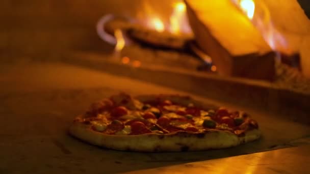 Італійська піца Пеппероні готується в печі, ресторанна піца готується в дерев'яній печі в традиційному ресторані.. — стокове відео