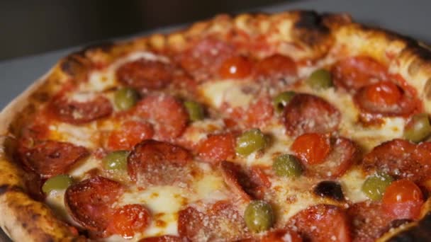 Primer plano de la apetitosa pizza Pepperoni con especias, hierbas, verduras frescas, salsa de tomate. Comida italiana, queso derretido . — Vídeos de Stock