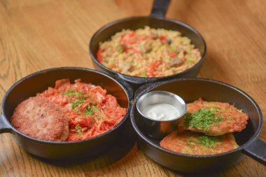 Ekşi kremalı patatesli gözleme, et ve sebzeli pilav ve kızartma tavuğunda servis edilen tavuk kiev pirzolası..