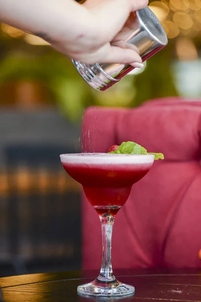 Cocktail alcolico estivo freddo con ghiaccio e frutta in un bicchiere alto su sfondo chiaro sfocato ristorante o caffè . — Foto Stock