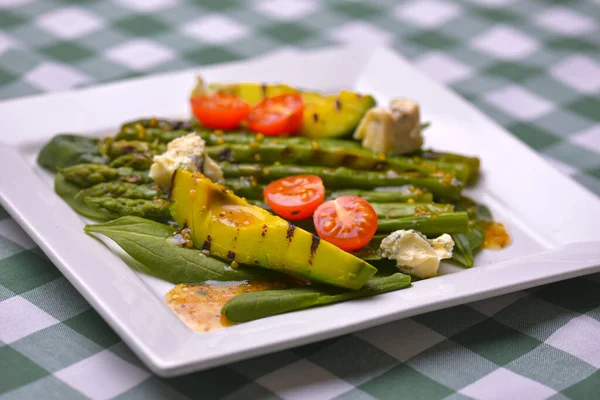 Salada saudável de abacate e espargos grelhados com sementes de linho e tomates. Servido em uma placa quadrada branca . — Fotografia de Stock