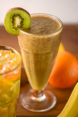 Kivi meyveli tropik içecek, kokteyller hafif ahşap masada servis edilir..
