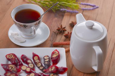 Lezzetli oryantal tatlılar. Kafkasya usulü leziz kilise kilisesi - Gürcü fındık ikramı. Bir bardak çay ve çaydanlıkla servis edilir..