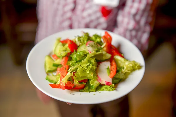 Garçom servindo salada de legumes com tomates suculentos, alface, rabanete, pepino. Serviço de restaurante . — Fotografia de Stock