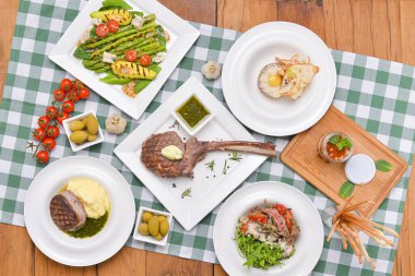 Yemek masası konsepti. İtalyan mutfağı, İtalyan konsepti. Düz pankart. Tomahawk bifteği, avokado ve kuşkonmaz salatası..