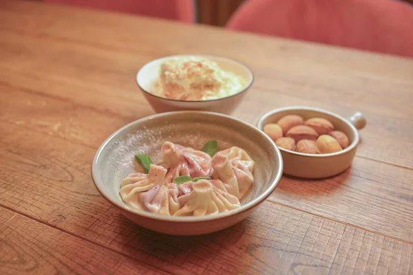 Khinkali dulce con cereza, galletas llamadas nueces con leche condensada y pastel Napoleón servido en platos blancos . — Foto de Stock