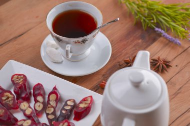 Lezzetli oryantal tatlılar. Kafkasya usulü leziz kilise kilisesi - Gürcü fındık ikramı. Bir bardak çay ve çaydanlıkla servis edilir..