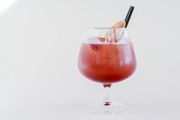 Холодный летний алкогольный коктейль со льдом и апельсином в небольшом стакане на белом фоне. — стоковое фото