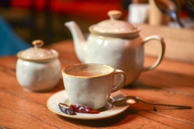 Restorandaki ahşap bir masada servis edilen beyaz çay seti. Çay zamanı. Seramik çay seti. Konsepti tüketiyorum.