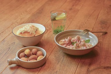 Kirazlı tatlı hinkali, Kurabiyeler fındıklı yoğurtlu süt ve Napolyon keki beyaz tabakta servis eder..