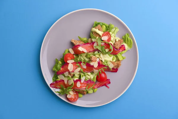 Salada fresca com salmão salgado defumado, tomates e sementes de abóbora. Servido em uma placa cinza sobre fundo textura cinza . — Fotografia de Stock