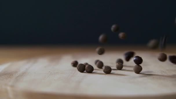 Clavo seco que cae sobre una mesa de madera rústica oscura sobre fondo negro en cámara lenta. Ingrediente alimentario picante . — Vídeos de Stock