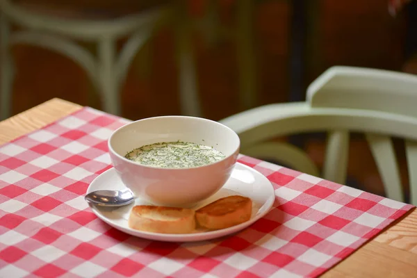 Okroshka. Sopa de iogurte frio leve de verão com pepino, rabanete, ovos e endro em uma tigela. Jantar no restaurante . — Fotografia de Stock