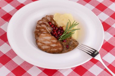 Tuzlu ve otlu ızgara biftek. Patates püresi ve nar tohumlarıyla servis edilir..