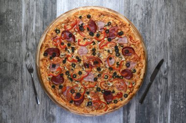 Lezzetli İtalyan pizzasının kır ağacında çekilmiş düz bir fotoğrafı. Pepperoni, peynir ve biber. Lezzetli yemek..