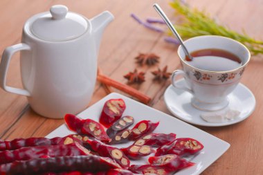 Lezzetli oryantal tatlılar. Kafkasya usulü leziz kilise kilisesi - Gürcü fındık ikramı. Bir bardak çay ve çaydanlıkla servis edilir..