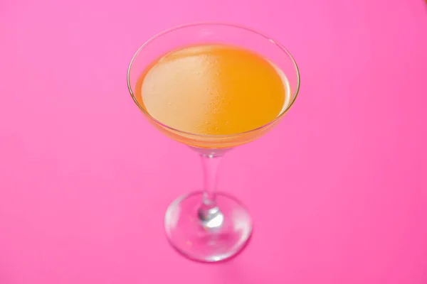 Hideg nyár sárga alkohol Martini koktél egy Martini pohár elszigetelt élénk rózsaszín háttér. — Stock Fotó