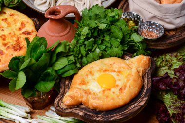Geleneksel Gürcü mutfağı. Geleneksel Ajarian ekmek khachapuri. Peynirli ve yumurtalı açık turta.