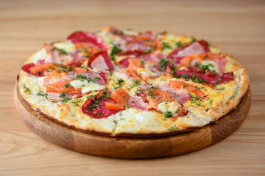 Tahtada domatesli, peynirli ve mantarlı taze pizza, ahşap masa arkası yakın plan..