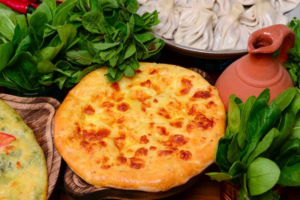 Geleneksel Gürcistan Kolkh khachapuri, masada süluguni ve brynza peyniri. Khachapuri Megruli. Ev yapımı pişirme..