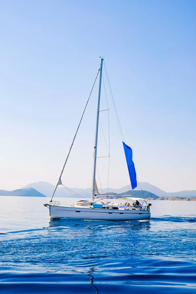 Racing yacht in the sea on blue sky background. Peaceful seascape. Beautiful blue sky over calm sea.