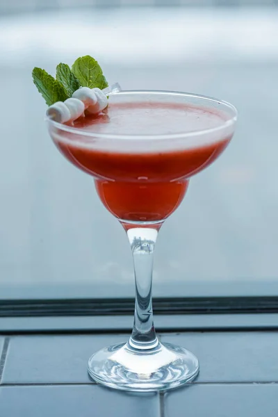 Koude zomer alcohol cocktail met ijs en fruit in een hoog glas op licht wazig restaurant of cafe achtergrond. — Stockfoto