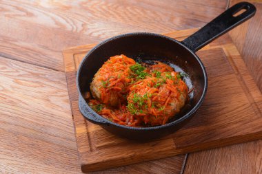 Sebzeli ve etli güveç. Tavada basit bir güveç. Kırsal ahşap arka planda ahşap bir tahtada servis edilmiş..