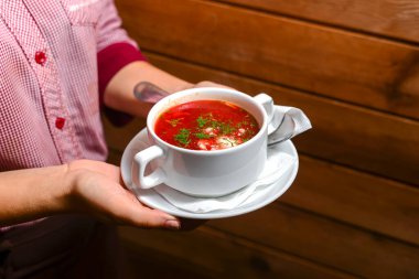 Bir kase çorba tutan bir adam. Garson lokantada ya da restoranda taze çorba servis ediyor. Sağlıklı, lezzetli yemek..