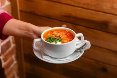 Bir kase çorba tutan bir adam. Garson lokantada ya da restoranda taze çorba servis ediyor. Sağlıklı, lezzetli yemek..